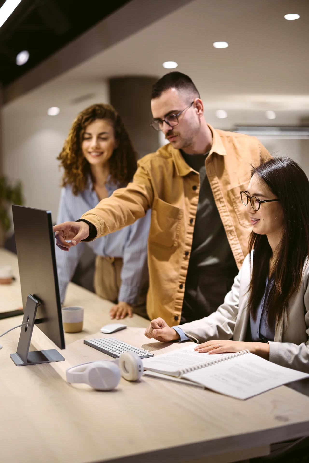 Three colleagues collaborating at a computer.